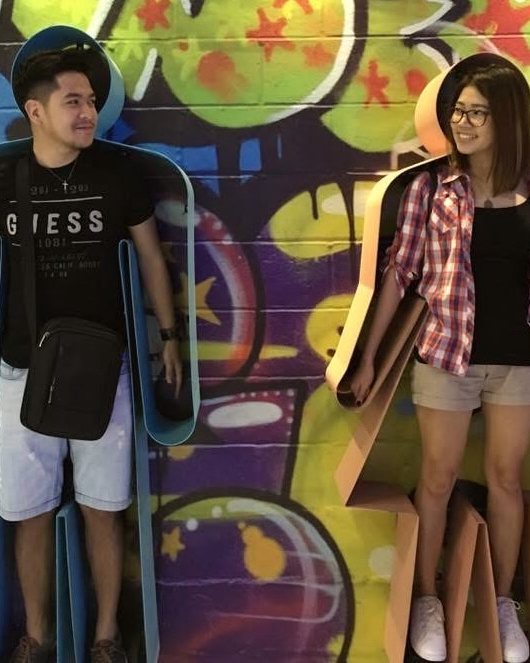 Justin and Nina in front of a painted wall